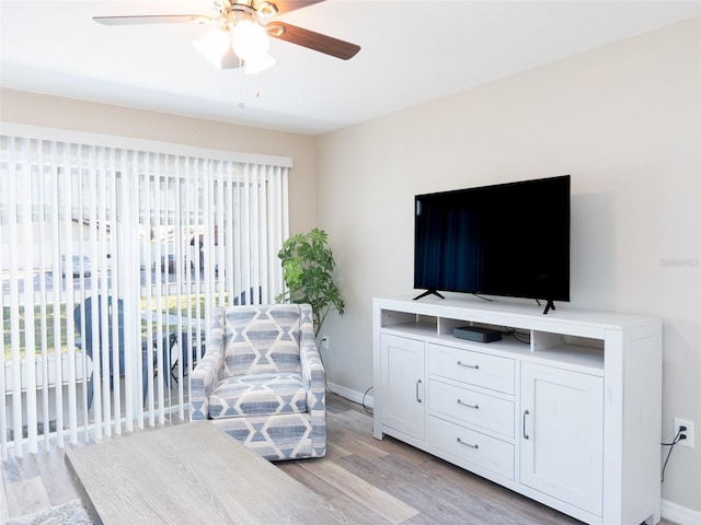 interior space with baseboards, a ceiling fan, and light wood-type flooring