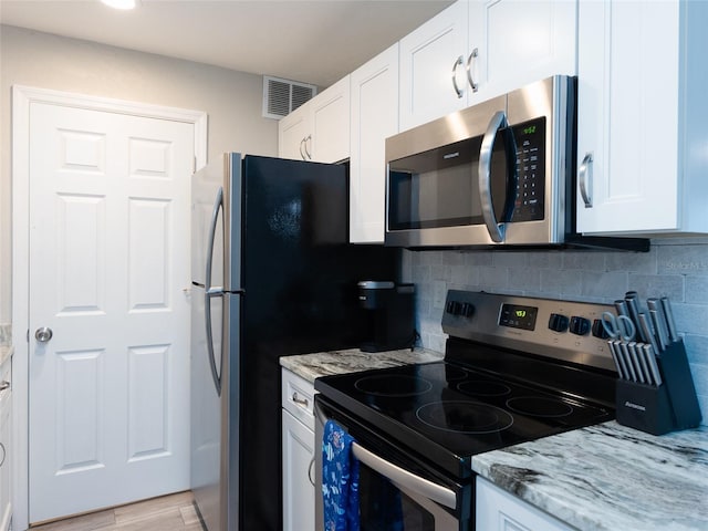 kitchen featuring visible vents, white cabinetry, appliances with stainless steel finishes, and light stone countertops