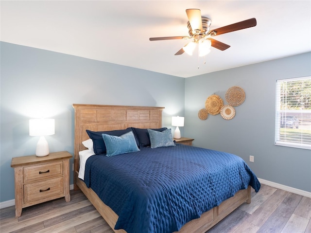 bedroom featuring a ceiling fan, baseboards, and light wood-type flooring