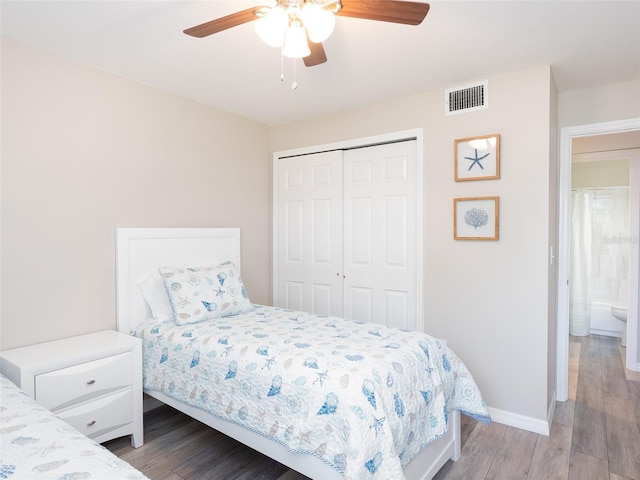 bedroom featuring ceiling fan, visible vents, wood finished floors, baseboards, and a closet