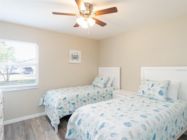 bedroom featuring baseboards, ceiling fan, and light wood finished floors