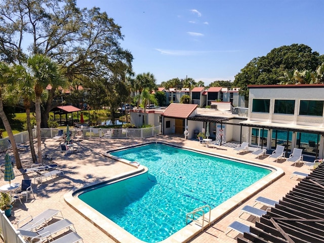 community pool with fence and a patio