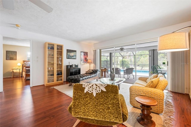 living room with ceiling fan, a textured ceiling, a sunroom, and wood finished floors