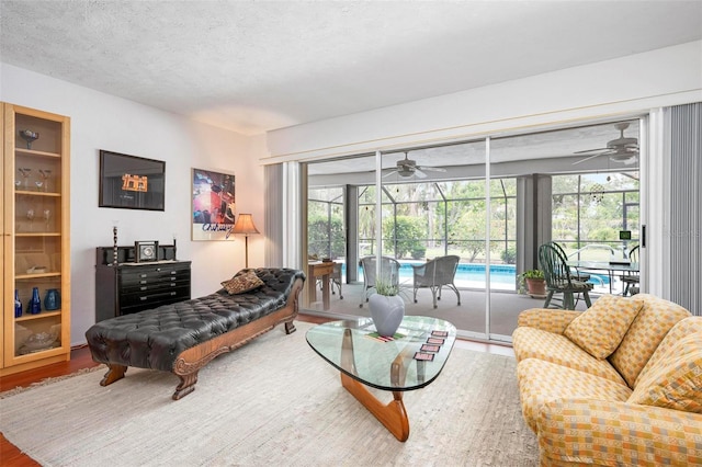 living room featuring a sunroom, a healthy amount of sunlight, and ceiling fan