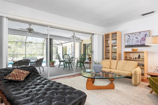 bedroom featuring a sunroom, access to outside, visible vents, and wood finished floors