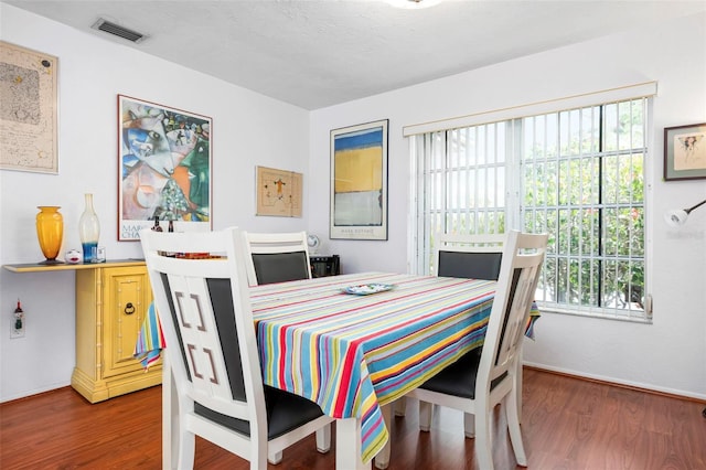 dining area with a wealth of natural light, baseboards, visible vents, and wood finished floors