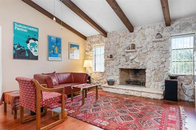 living area featuring plenty of natural light, wood finished floors, a fireplace, and lofted ceiling with beams