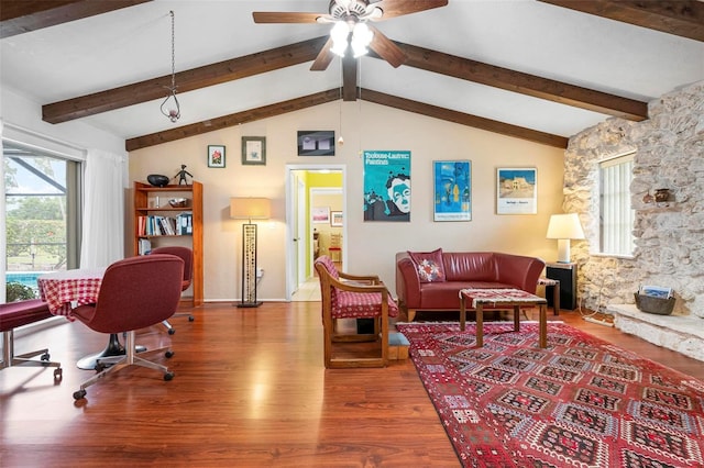 living area featuring baseboards, lofted ceiling with beams, ceiling fan, and wood finished floors