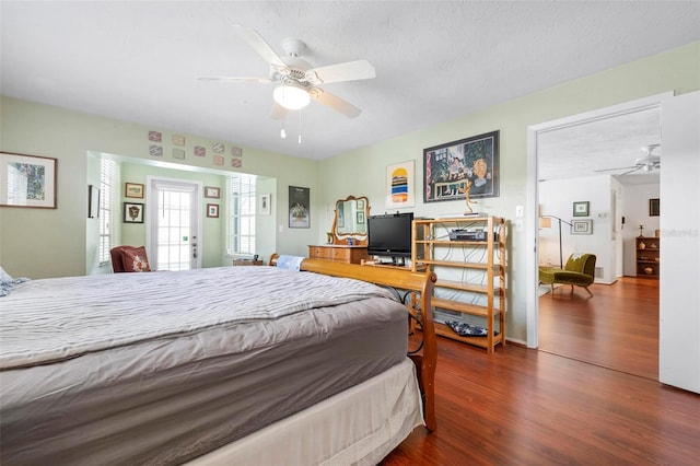 bedroom featuring a ceiling fan, a textured ceiling, and wood finished floors