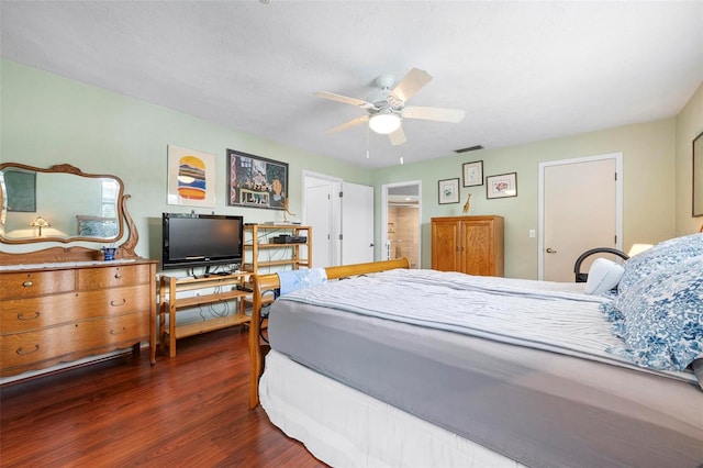 bedroom featuring dark wood finished floors, visible vents, and a ceiling fan