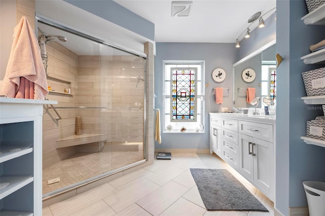 bathroom with a stall shower, vanity, and plenty of natural light
