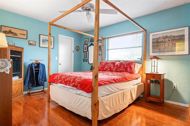bedroom featuring wood finished floors, baseboards, and ceiling fan