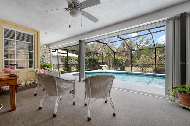 pool with a patio, ceiling fan, and glass enclosure