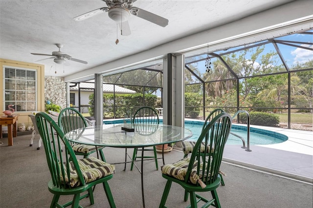 sunroom with ceiling fan, outdoor dining area, and a swimming pool