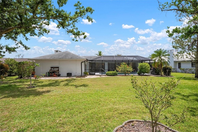 rear view of house featuring a lawn, stucco siding, and a lanai