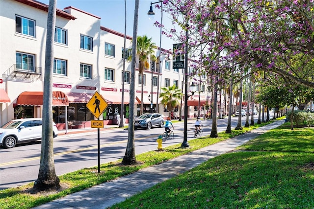 view of street with street lights, traffic signs, curbs, and sidewalks