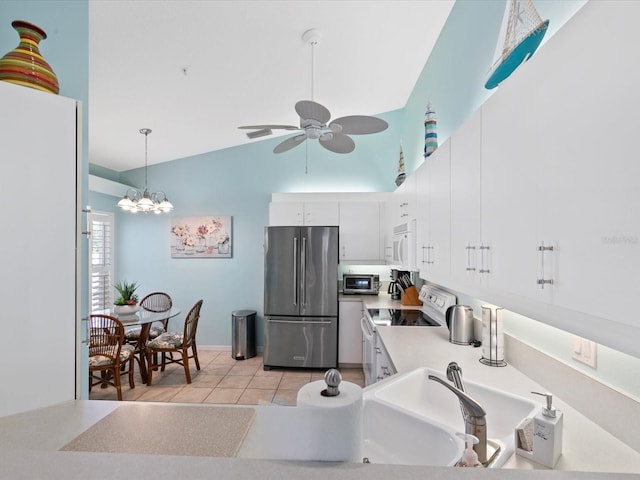 kitchen with light countertops, ceiling fan with notable chandelier, stainless steel appliances, white cabinetry, and light tile patterned floors