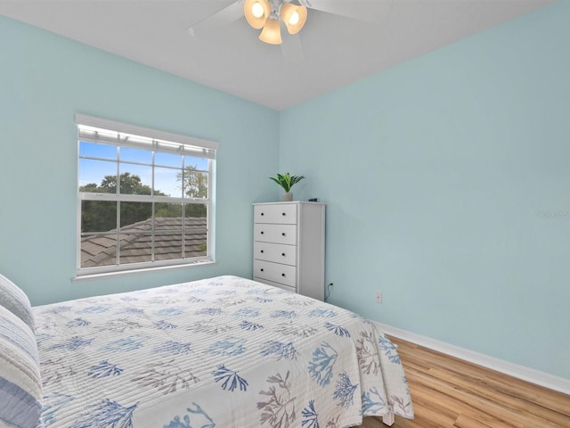 bedroom with baseboards, ceiling fan, and wood finished floors