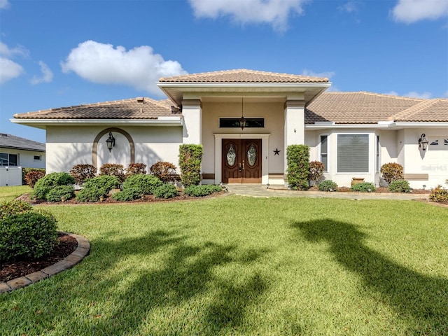 314 Oakwood Cir, Englewood, FL 34223 - view of front of house featuring stucco siding, a tile roof, and a front yard
