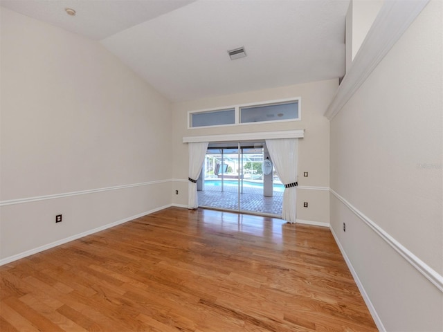 314 Oakwood Cir, Englewood, FL 34223 - spare room featuring baseboards, light wood finished floors, visible vents, and vaulted ceiling