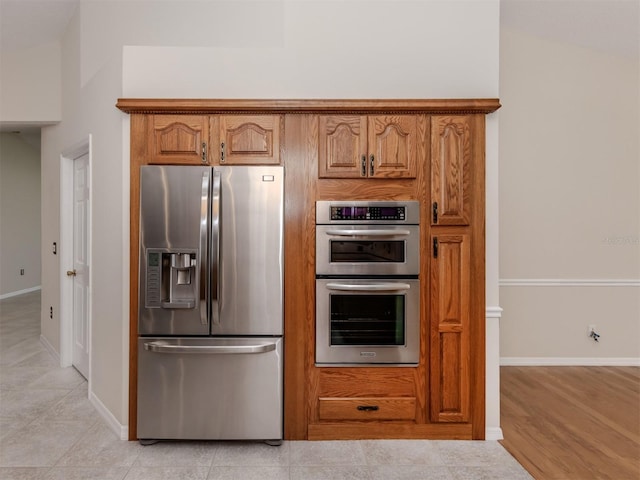 314 Oakwood Cir, Englewood, FL 34223 - kitchen with brown cabinetry, baseboards, and appliances with stainless steel finishes