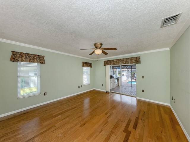 314 Oakwood Cir, Englewood, FL 34223 - spare room featuring a textured ceiling, visible vents, wood finished floors, and a ceiling fan