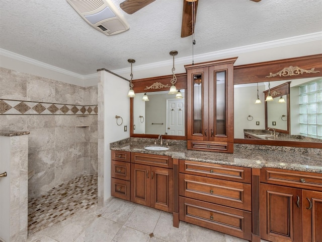 314 Oakwood Cir, Englewood, FL 34223 - bathroom featuring double vanity, a ceiling fan, a sink, a walk in shower, and crown molding