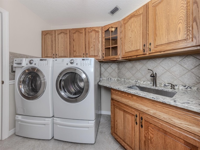 314 Oakwood Cir, Englewood, FL 34223 - clothes washing area featuring a sink, cabinet space, visible vents, separate washer and dryer, and light tile patterned floors