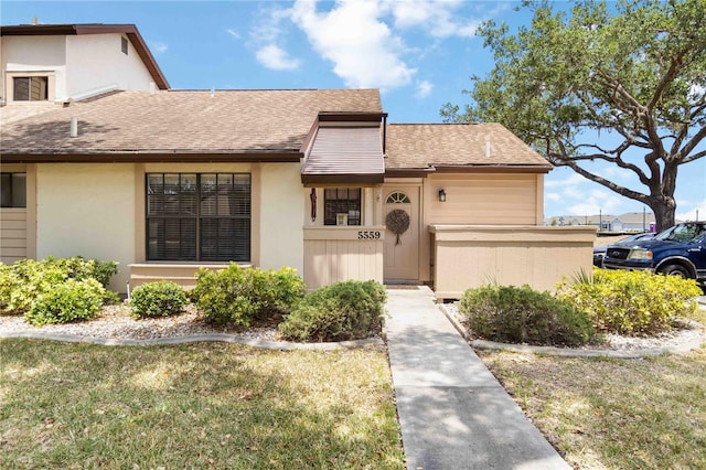 5559 Brassy Loop, North Port, FL 34287 - view of front of property with roof with shingles, stucco siding, and a front lawn
