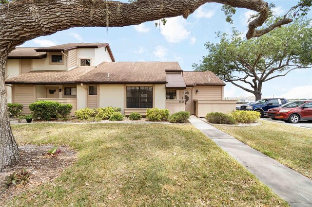 5559 Brassy Loop, North Port, FL 34287 - view of front of property with a front lawn, stucco siding, and roof with shingles