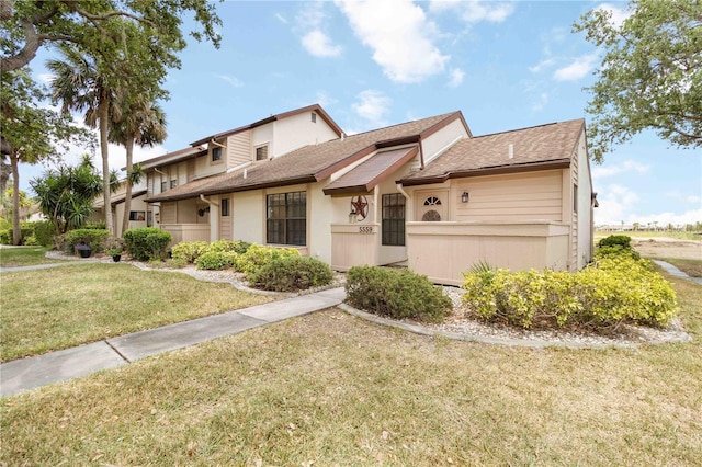 5559 Brassy Loop, North Port, FL 34287 - view of front of house featuring a front lawn, roof with shingles, and stucco siding