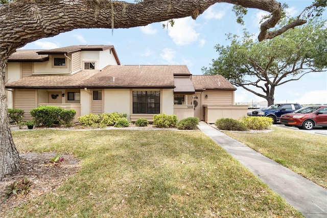 5559 Brassy Loop, North Port, FL 34287 - view of front of property with a front yard, stucco siding, and roof with shingles