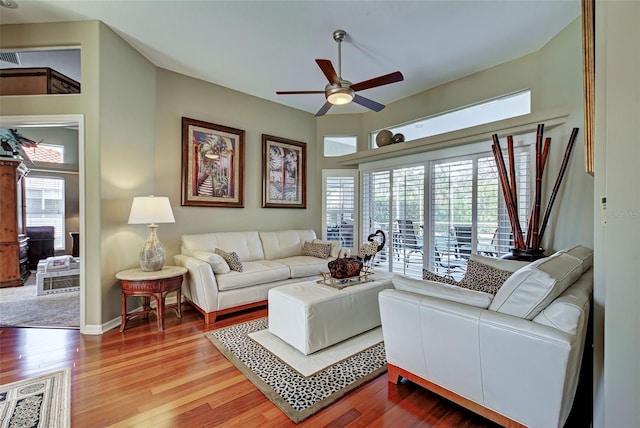 living room with baseboards, ceiling fan, and wood finished floors