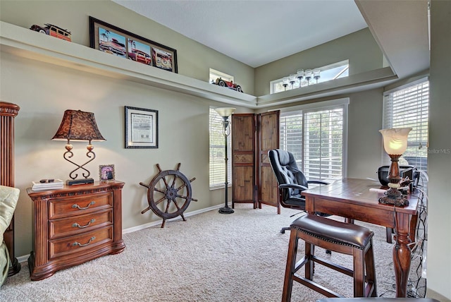 office area featuring baseboards and light carpet
