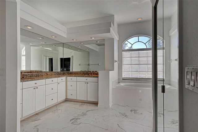 full bath featuring recessed lighting, double vanity, marble finish floor, and a bath