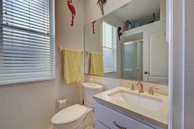 full bathroom featuring vanity, toilet, and a shower stall