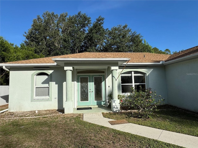 1483 Prairie Ter, North Port, FL 34286 - view of front of property with stucco siding, a front yard, french doors, and roof with shingles