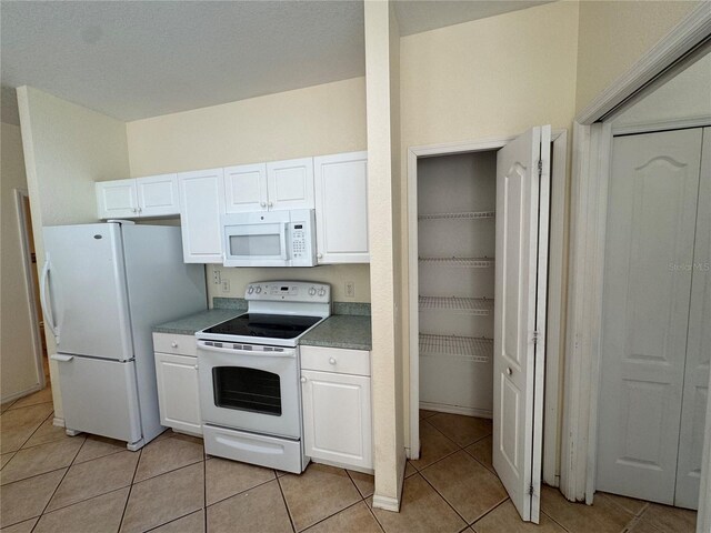 1483 Prairie Ter, North Port, FL 34286 - kitchen featuring white appliances, white cabinets, and light tile patterned floors