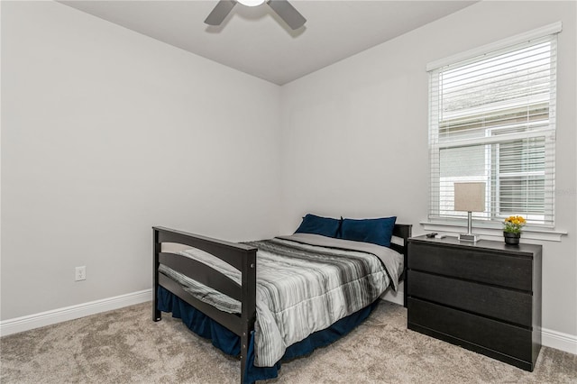 carpeted bedroom featuring baseboards and ceiling fan