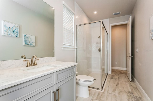 full bath featuring a stall shower, toilet, and vanity