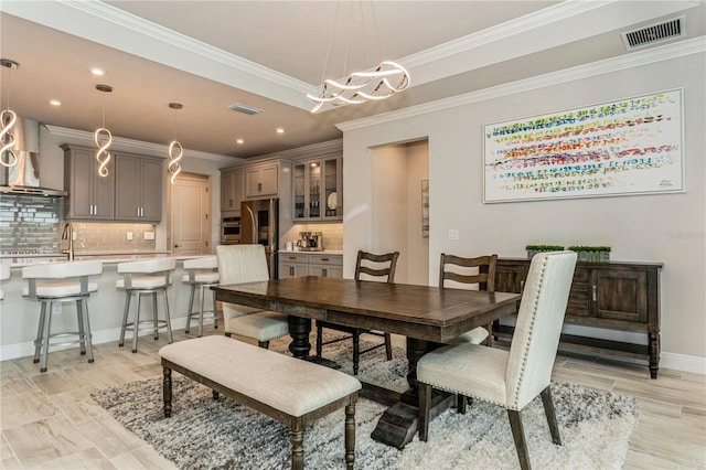 dining space featuring baseboards, crown molding, recessed lighting, a chandelier, and light wood-style flooring