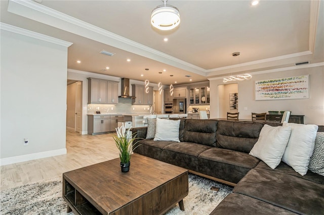 living room with ornamental molding, baseboards, recessed lighting, and light wood-type flooring