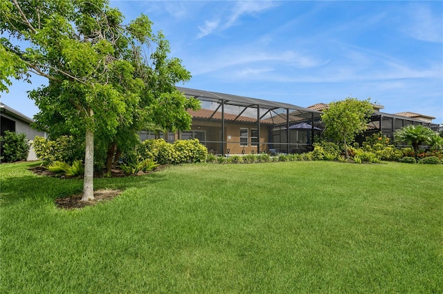 view of green lawn with a lanai