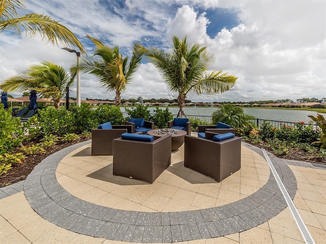 view of patio / terrace featuring fence, a water view, and a fire pit