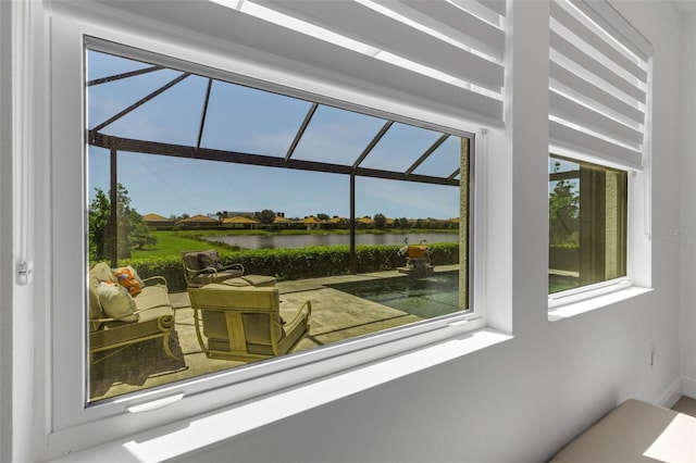 sunroom featuring a water view