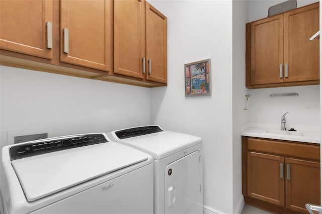 washroom with washer and dryer, a sink, and cabinet space