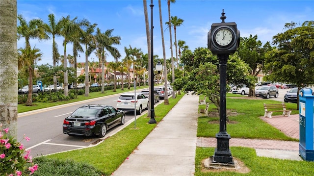 view of home's community featuring a lawn and uncovered parking