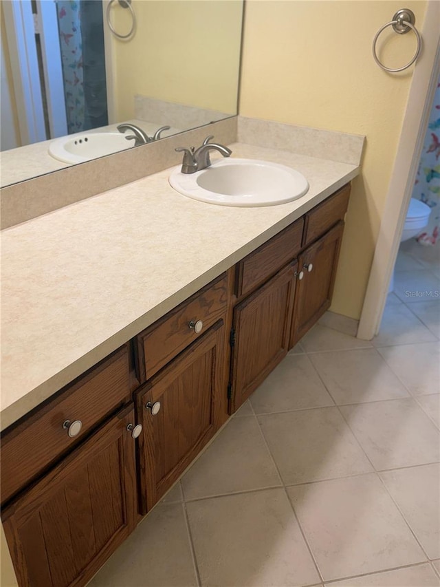 bathroom featuring tile patterned floors, baseboards, and vanity