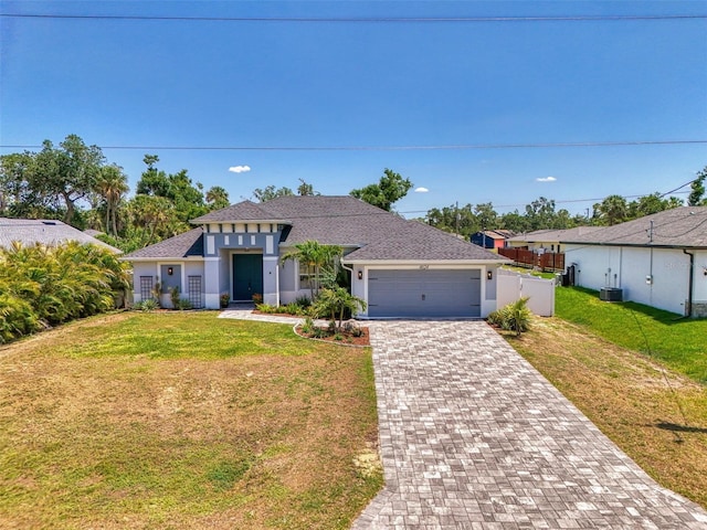 view of front of home featuring a garage, decorative driveway, stucco siding, roof with shingles, and central air condition unit