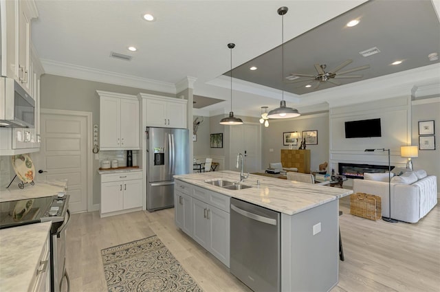 kitchen with stainless steel appliances, a sink, crown molding, a ceiling fan, and decorative backsplash